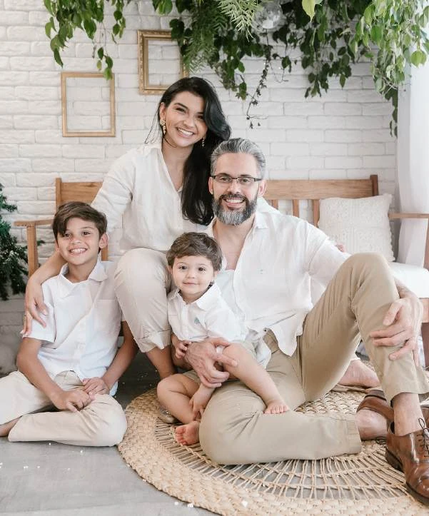 Família com duas crianças sentada no cenário natalino